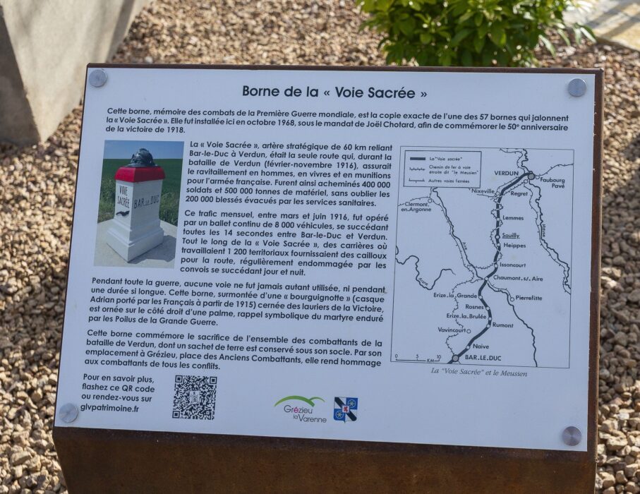 Borne de la "Voie Sacrée" Cette borne, mémoire des combats de la Première Guerre mondiale, est la copie exacte de l’une des 57 bornes qui jalonnent la « Voie Sacrée ». Elle fut installée ici en octobre 1968, sous le mandat de Joël Chotard, afin de commémorer le 50e anniversaire de la victoire de 1918. La « Voie Sacrée », artère stratégique de 60 km reliant Bar-le-Duc à Verdun, était la seule route qui, durant la bataille de Verdun (février-novembre 1916), assurait le ravitaillement en hommes, en vivres et en munitions pour l’armée française. Furent ainsi acheminés 400 000 soldats et 500 000 tonnes de matériel, sans oublier les 200 000 blessés évacués par les services sanitaires. Ce trafic mensuel, entre mars et juin 1916, fut opéré par un ballet continu de 8 000 véhicules, se succédant toutes les 14 secondes entre Bar-le-Duc et Verdun. Tout le long de la « Voie Sacrée », des carrières où travaillaient 1 200 territoriaux fournissaient des cailloux pour la route, régulièrement endommagée par les convois se succédant jour et nuit. Pendant toute la guerre, aucune voie ne fut jamais autant utilisée, ni pendant une durée si longue. Cette borne, surmontée d’une « bourguignotte » (casque Adrian porté par les Français à partir de 1915) cernée des lauriers de la Victoire, est ornée sur le côté droit d’une palme, rappel symbolique du martyre enduré par les Poilus de la Grande Guerre. Cette borne commémore le sacrifice de l’ensemble des combattants de la bataille de Verdun, dont un sachet de terre est conservé sous son socle. Par son emplacement à Grézieu, place des Anciens Combattants, elle rend hommage aux combattants de tous les conflits. Pour en savoir plus, flashez ce QR code ou rendez-vous sur glvpatrimoine.fr
